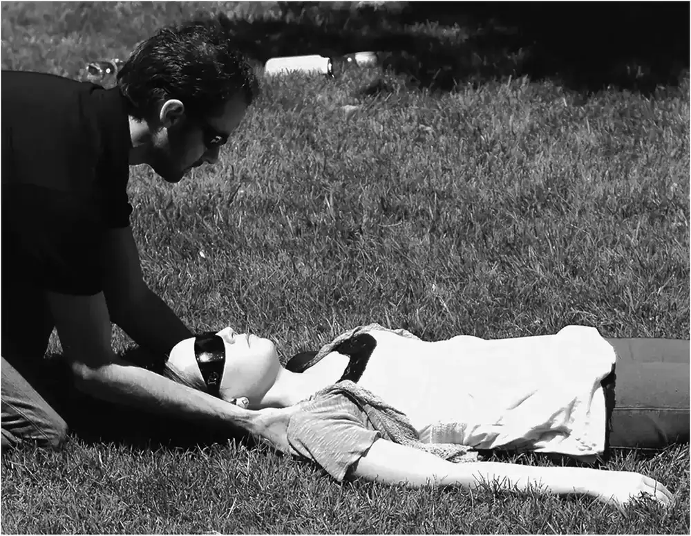 Figure 1. Demonstration of trap squeeze technique for manual cervical spine stabilization. (Quinn et al. Reprinted with permission from the Wilderness Medical Society. ©2014 Wilderness Medical Society.)